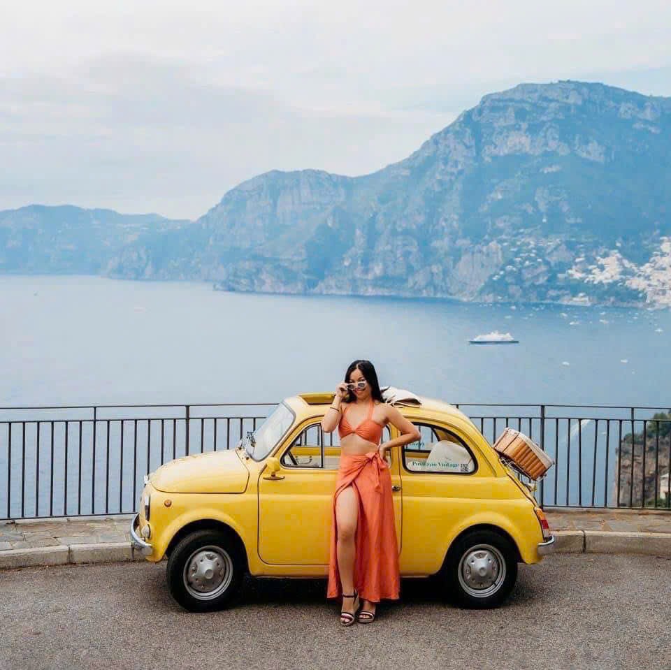Quyên Đào bên chiếc xe Fiat 500 màu vàng tại Positano, Ý